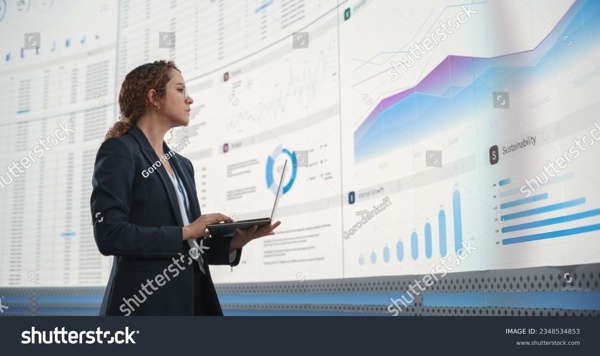 stock-photo-in-the-monitoring-office-successful-hispanic-businesswoman-holding-laptop-computer-and-analyzing-2348534853.jpg